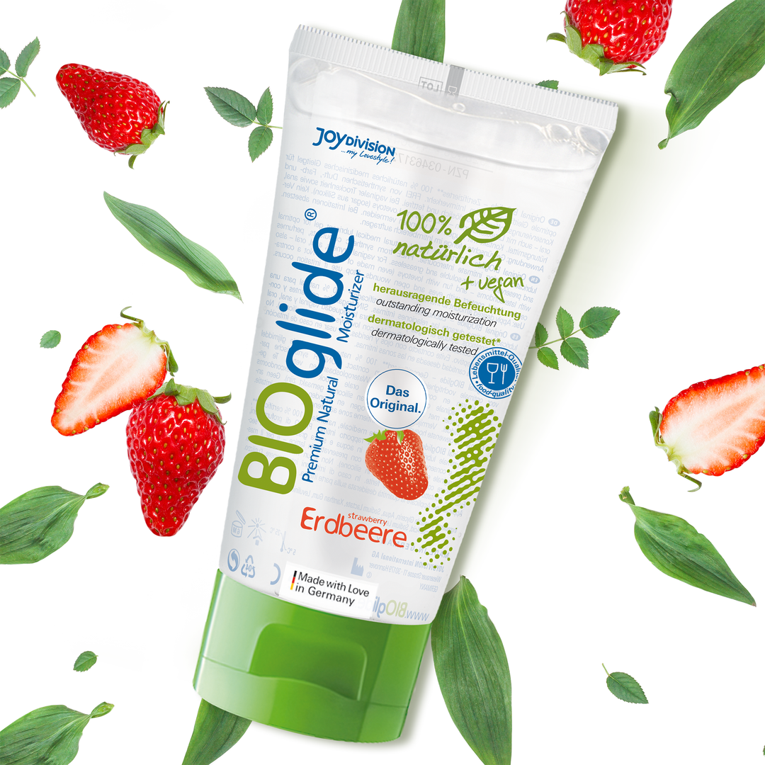 Tube of BIOglide with strawberries and leaves on a white background